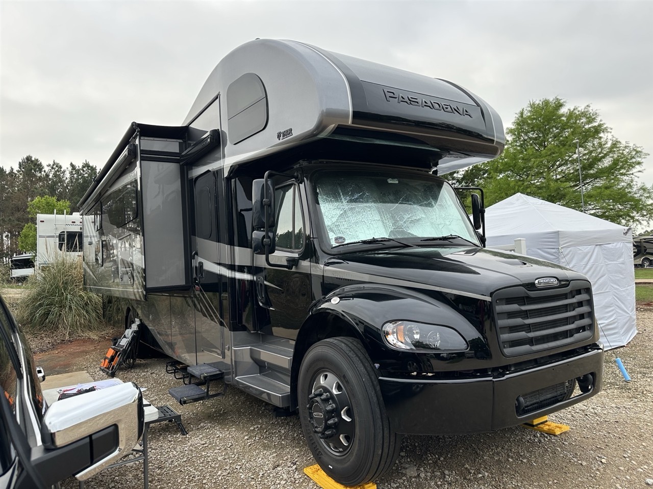 A Pasadena Super C diesel motorhome parked at a campground